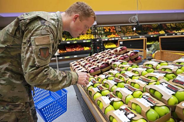 A U.S. Air Force Airman selects produce while grocery shopping at Ramstein.
