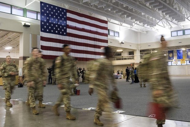 Soldiers walk past a large American flag at Hunter Army Airfield in Georgia.