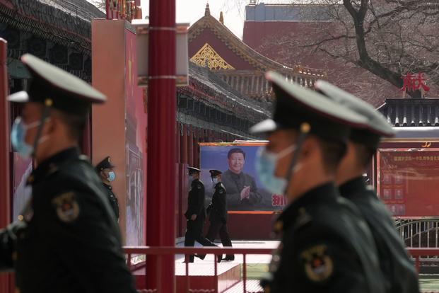 A poster showing Chinese President Xi Jinping is seen outside barracks at the Forbidden City.