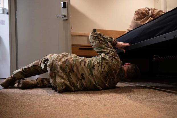 airman inspecting under cot in dorm 
