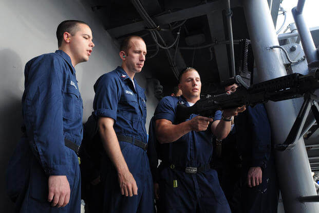 Petty Officer 2nd Class Zach Bernat demonstrates proper handling and safety procedures of the M240B machine gun
