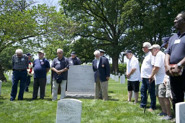 Survivors of the USS Liberty stand in front of the memorial at Arlington National Cemetery.
