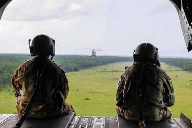 Soldiers sit on the back of a CH-47.