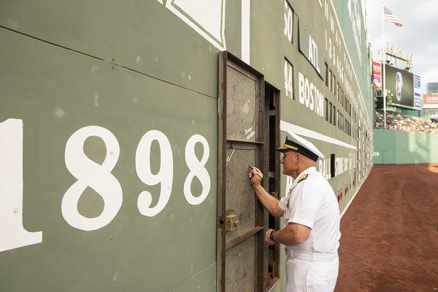 Chief of Naval Operations Adm. Mike Gilday signed the ‘Green Monster’ during a Red Sox game at Fenway Park in Boston after enlisting several future sailors.