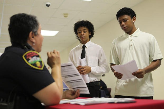 Devontae and Akiva Battle speak to a police officer about the Sturgeon City Institutes summer program.