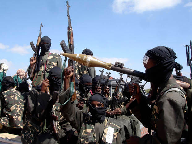 Armed al-Shabab fighters ride on pickup trucks as they prepare to travel into the city