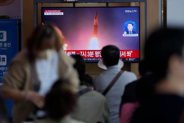 A TV screen showing a news program reporting about North Korea's missile launch with file imagery.
