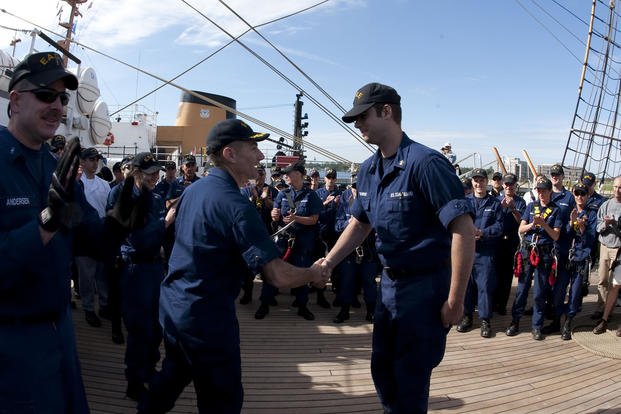 Capt. Eric Jones, U.S. Coast Guard Cutter Eagle's commanding officer, shakes hands with Petty Officer First Class Henry Cylkowski after a promotion ceremony onboard the Eagle.