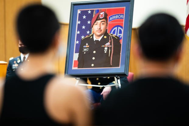 Friends of Spc. Enrique Roman-Martinez sit silently during his memorial ceremony at The All American Chapel on Fort Bragg, N.C.