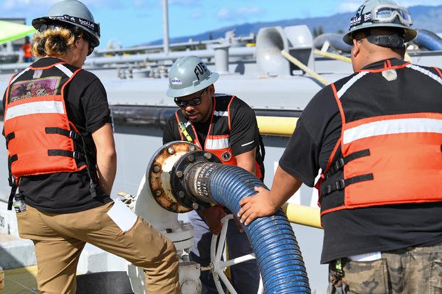 Naval Supply Systems Command Fleet Logistics Center Pearl Harbor fuel distribution system workers turn a valve to begin unpacking F76 marine diesel fuel during an unpacking operation onboard Joint Base Pearl Harbor-Hickam (JBPHH), Hawaii, Oct. 27, 2022.