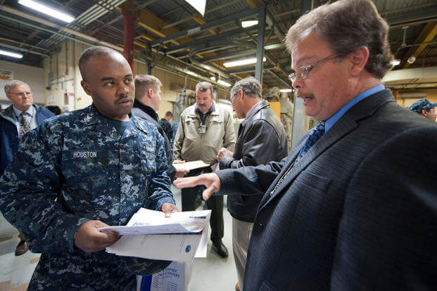 Electrician's Mate 1st Class Charles L. Houston speaks with Martin D. Gillium, a Norfolk Naval Shipyard engineer technician, about career opportunities during a Shipmates to Workmates career forum at the Norfolk Naval Shipyard.