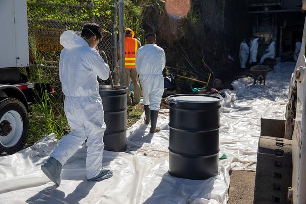 Employees work to remove contaminated soil from the spill site in Hawaii. 