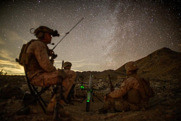 U.S. Marine Corps Lance Cpl. Dylan Neylon, a 60mm mortar section leader (left); Lance Cpl. Isaiah Foshay, a 60mm mortar gunner; and Lance Cpl. Joseph Cucchira, a 60mm mortar assistant gunner with 3d Battalion, 7th Marine Regiment, 1st Marine Division, stand by for a fire mission during their Marine Corps Combat Readiness Evaluation at Marine Corps Air Ground Combat Center Twentynine Palms, California.