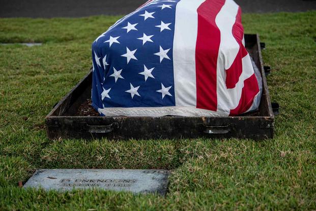 U.S. flag is draped over a casket during a disinterment ceremony.