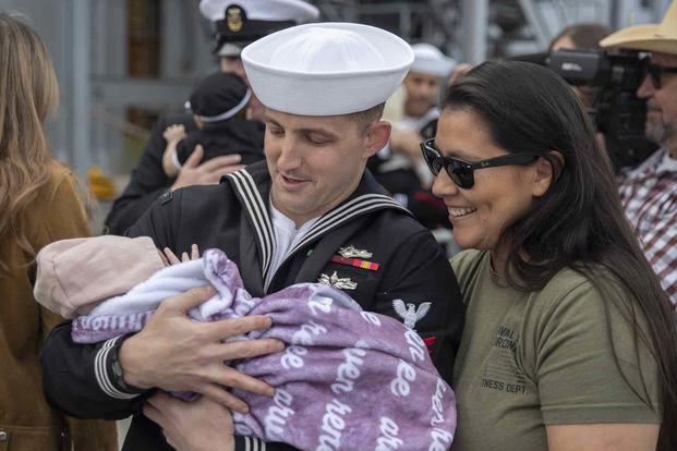 A U.S. Navy sailor holds his newborn baby for the first time.
