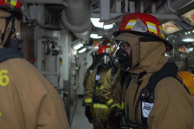 Damage controlman fireman Seaman Michael Minotti assembles with fellow sailors in the aft galley during a nuclear power mobile training team drill aboard the Nimitz-class aircraft carrier USS Ronald Reagan. 