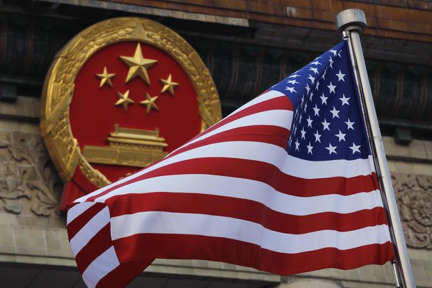 An American flag is flown next to the Chinese national emblem.