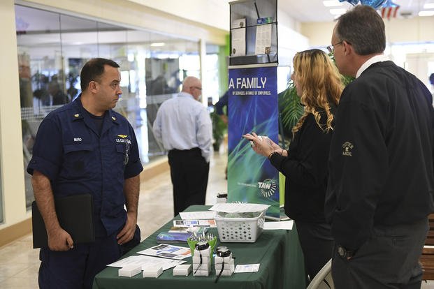 Coast Guard Petty Officer 1st Class Eric Muro speaks with two training managers at the City of Jacksonville's Week of Valor Veterans and Military Job and Resources Fair.