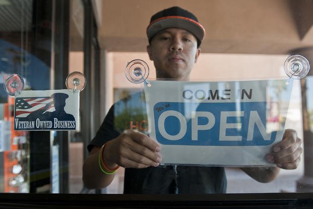 Retired Tech. Sgt. Alfredo Sibucao Jr. flips the open sign to his retail store in Las Vegas.