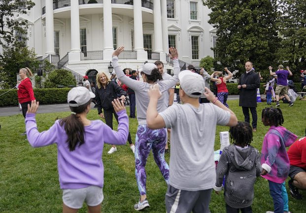 First lady Jill Biden walks though kids and families as they workout on the South Lawn of the White House.