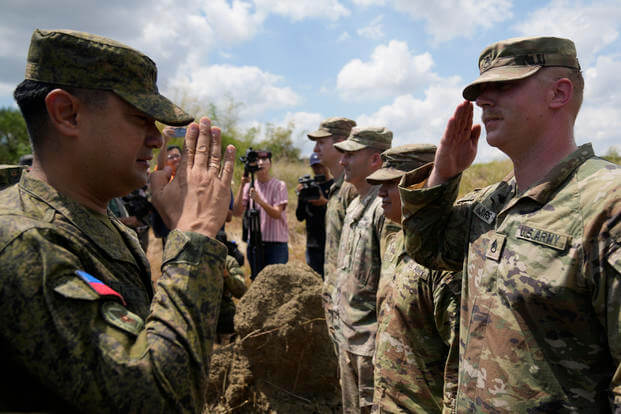 Philippine Army Artillery Regiment Commander Anthony Coronel returns a salute from a US soldier