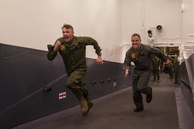 Lt. Col. Kyle Shoop, commanding officer, Marine Fighter Attack Squadron-211, 13th Marine Expeditionary Unit, and Cpl. Garrett Ross (left), plane captain, VMFA-211, 13th MEU, compete in a race during a unit competition.