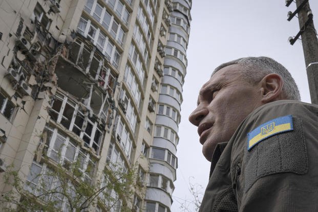 Kyiv Mayor Vitali Klitschko stands in front of an apartment building damaged by a drone