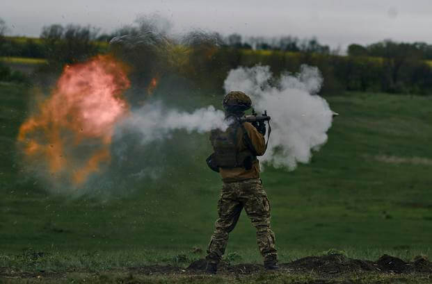 A Ukrainian soldier fires an RPG during his training at the frontline positions