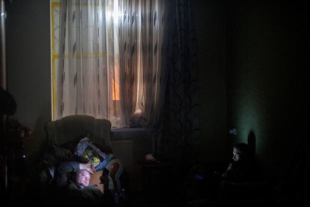 Ukrainian soldiers check their phones during a lull in the fighting.