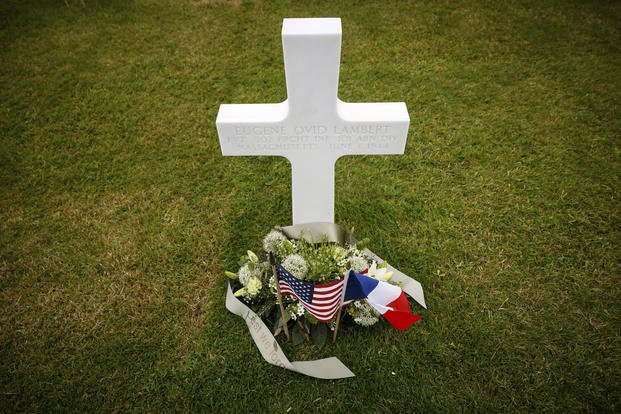 American flag and French flag lay at headstones in the American Cemetery in Colleville-sur-Mer, Normandy