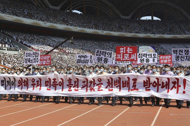 Pyongyang people take part in a demonstration after a mass rally
