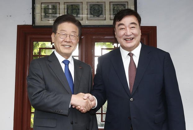 Chinese Ambassador to South Korea Xing Haiming, right, shakes hands with South Korea's main opposition Democratic Party leader Lee Jae-myung