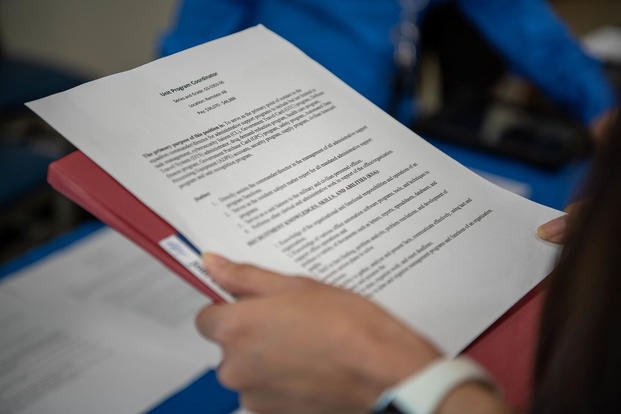 A military spouse carries a copy of their resume during a job fair at Ramstein Air Base, Germany.