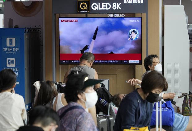 A TV screen shows an image of North Korea's missile launch during a news program
