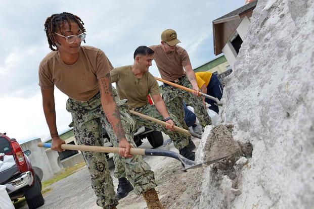 Service member shovels sand in preparation for Tropical Storm Idalia