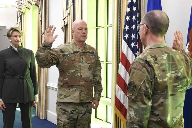 John W. Raymond administers the oath of enlistment to Chief Master Sgt. Roger A. Towberman