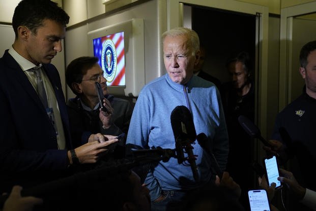 President Joe Biden talks to reporters aboard Air Force One.