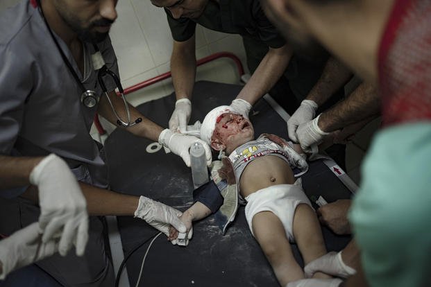 Palestinian medics surround a baby.