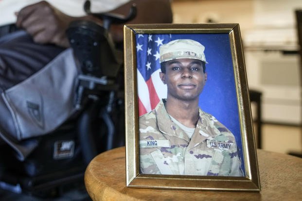 A portrait of Army Pvt. Travis King is displayed as his grandfather, Carl Gates, talks