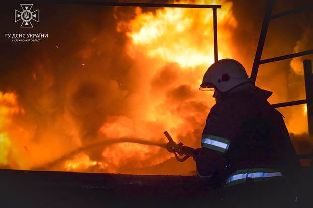 emergency services personnel work to extinguish a fire in Kharkiv, Ukraine