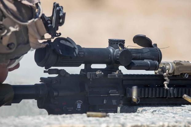 A U.S. Marine uses a squad common optic to conduct a live-fire drill