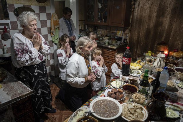 A family prays before a Christmas dinner in the Ukraine.
