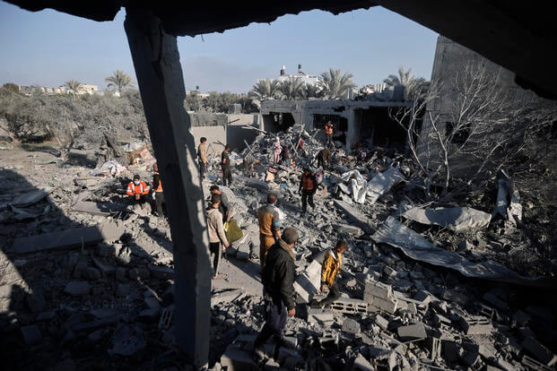 Palestinians inspect the damage of a destroyed house following Israeli airstrikes on Khan Younis