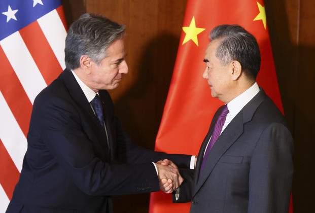U.S. Secretary of State Antony Blinken shakes hands with Chinese Foreign Minister Wang Yi.