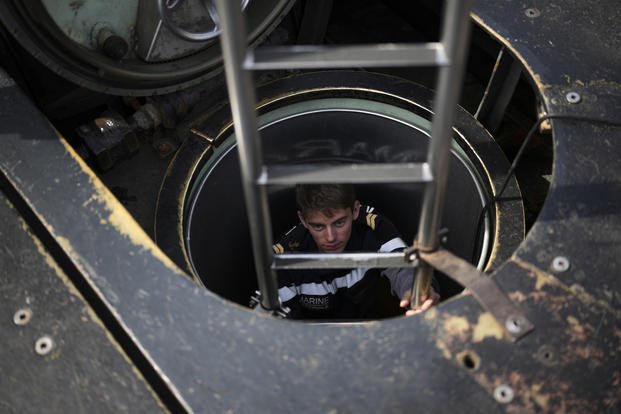 A sailor descends into a French Rubis-class submarine at the Toulon naval base