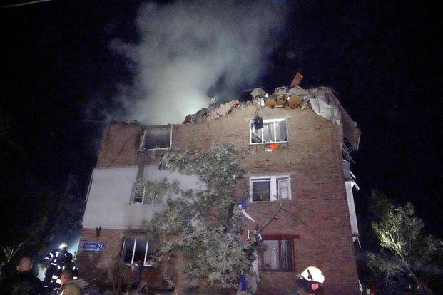 Firefighters put out a fire an apartment building damaged in the Russian missile attack in Kharkiv