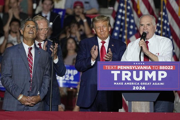 U.S. Rep. Mike Kelly, right, speaks as U.S. Rep. Dan Meuser, left, the Hon. Fred Keller, second from left, and Republican presidential candidate and former President Donald Trump look on during a Trump campaign rally in Erie, Pa.