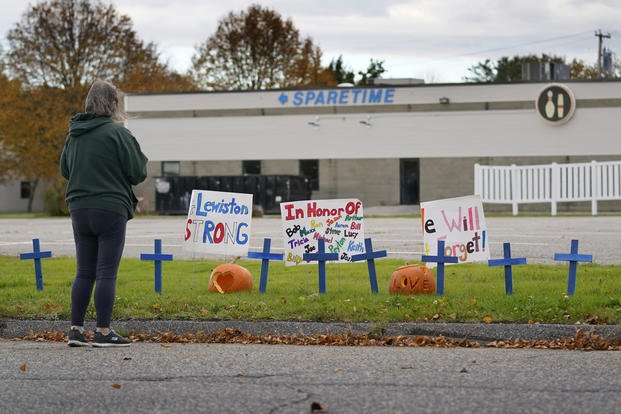 A woman visits a makeshift memorial outside Sparetime Bowling Alley, the site of a mass shooting