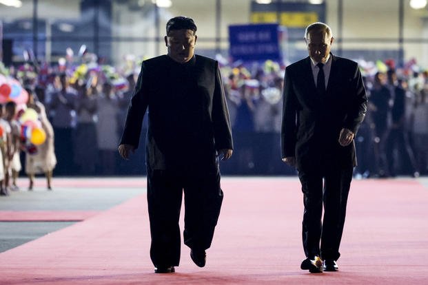 North Korea's leader Kim Jong Un, left, walks together with Russian President Vladimir Putin