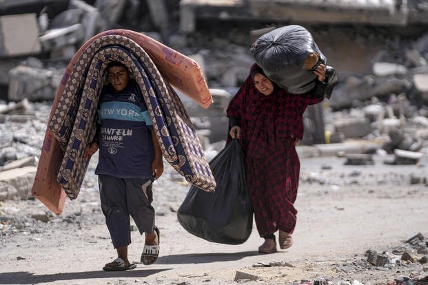 Palestinians displaced by the Israeli air and ground offensive on the Gaza Strip flee from Hamad City